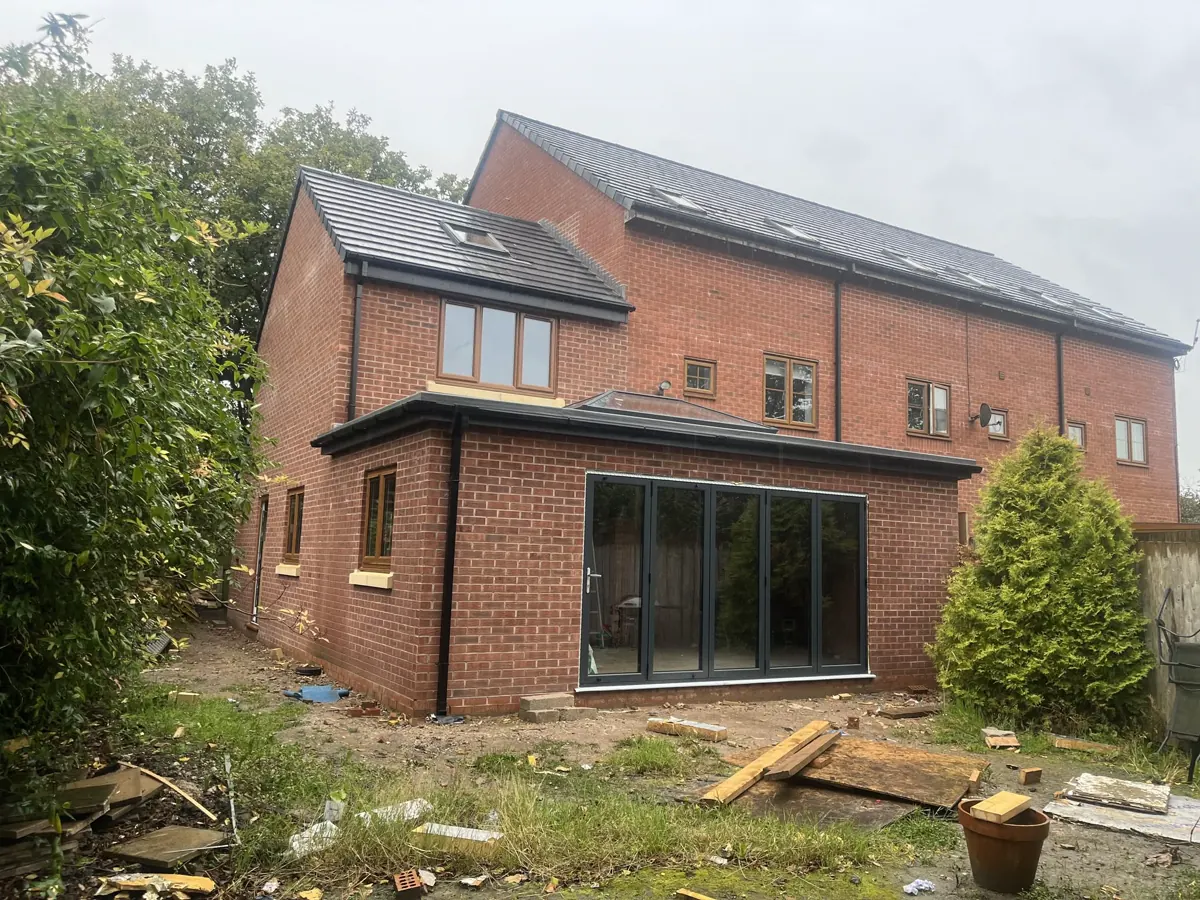 Brick home extension with external walls and roofline in progress